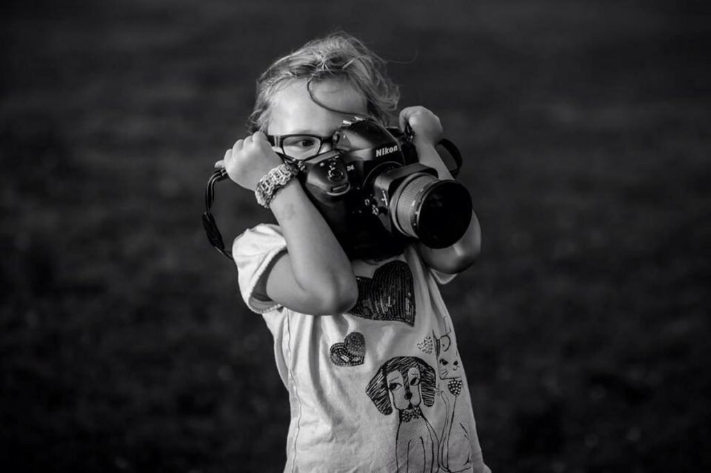 female child taking picture with camera