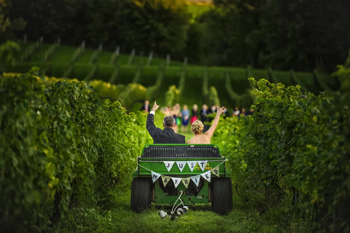 bride and groom riding in a 'just married' tractor