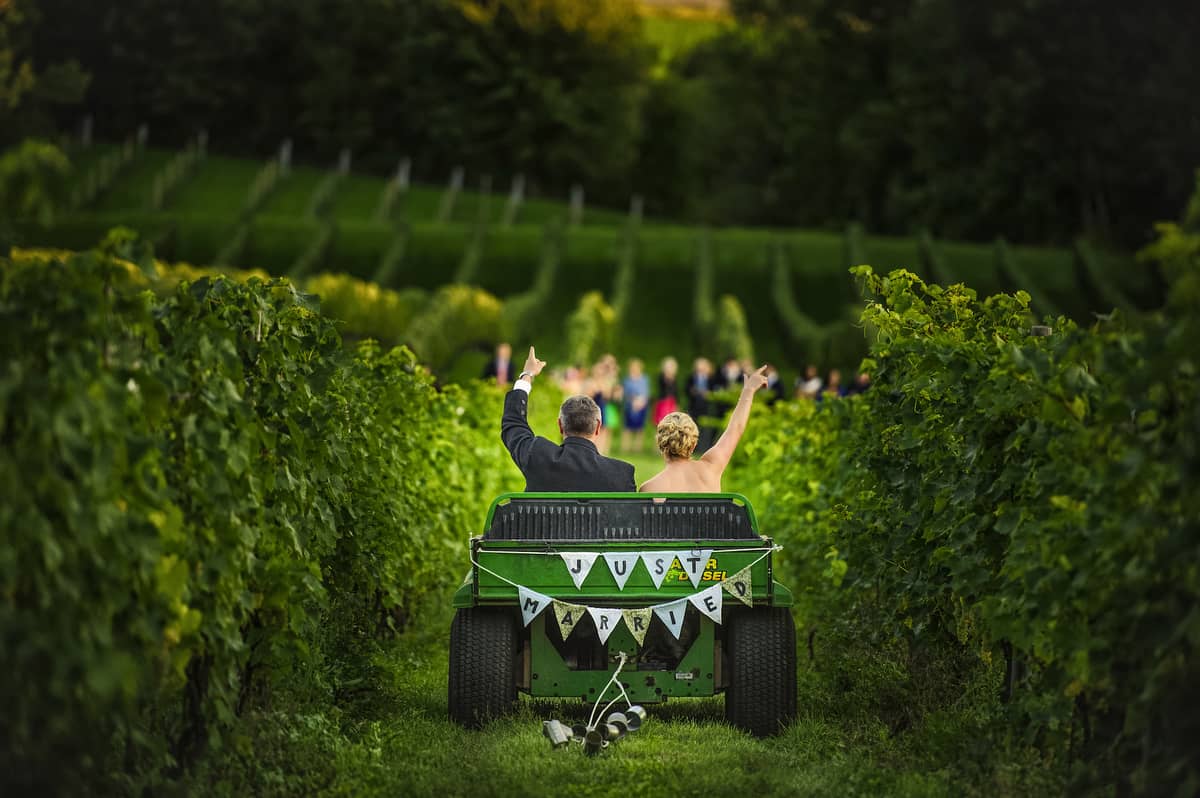 bride and groom riding in a 'just married' tractor